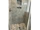 Modern shower featuring stone-look tiled walls, mosaic tile floor, recessed shelving, and sleek fixtures at 1601 Secessionville Rd, Charleston, SC 29412