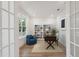 Bright home office with a built-in bookcase, wooden desk, blue accent chair and natural light from the nearby window at 1738 Cultivation Ln # 532, Mount Pleasant, SC 29466