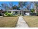 Charming single story home with lovely landscaping and a stone walkway to the front door at 1763 Three Oaks Ave, Charleston, SC 29407