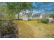 Back exterior view of the lovely home near the pond with a backyard featuring mature trees and landscaping at 1908 Oak Tree Ln, Mount Pleasant, SC 29464