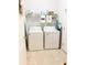Functional laundry room with washer, dryer, shelving for storage, and vinyl flooring for easy cleaning at 2117 Colson Ln, Johns Island, SC 29455