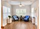 Cozy sunroom with large windows, ceiling fan, hardwood floors, and comfortable chairs perfect for relaxation at 2117 Colson Ln, Johns Island, SC 29455