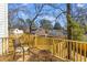 Relaxing outdoor deck space featuring natural wood railing, chair, and table, surrounded by mature trees and greenery at 2193 Helm Ave, North Charleston, SC 29405