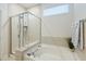 Elegant bathroom with a glass-enclosed shower, soaking tub, tile surround, and a window at 310 Silent Bluff Dr, Summerville, SC 29486