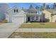 Charming two-story home features manicured lawn, attached garage, and inviting front porch at 310 Silent Bluff Dr, Summerville, SC 29486
