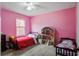 Bright pink bedroom with hardwood floors, two beds and doll house at 311 Macgregor Dr, Summerville, SC 29486