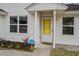 Close-up of the home's entrance featuring a yellow door, siding, and landscaping at 311 Macgregor Dr, Summerville, SC 29486