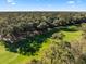 An aerial view of the property showing a golf course surrounded by verdant forest on a sunny day at 385 Green Winged Teal Rd, Kiawah Island, SC 29455