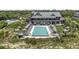 Aerial view of a resort-style pool and beach club with striped umbrellas on a beautiful sunny day at 385 Green Winged Teal Rd, Kiawah Island, SC 29455