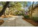 Long driveway leading to this home, showing mature trees with an American flag out front at 385 Green Winged Teal Rd, Kiawah Island, SC 29455