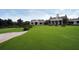 A manicured golf course and clubhouse sit ready for a day of play with red Adirondack chairs at 385 Green Winged Teal Rd, Kiawah Island, SC 29455