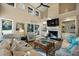 Bright living room features high ceilings with a fan, a fireplace, built-in shelves, and neutral-toned furnishings at 385 Green Winged Teal Rd, Kiawah Island, SC 29455