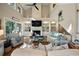 Spacious living room with high ceilings, a fan, fireplace, built-in shelves, and neutral-toned furnishings at 385 Green Winged Teal Rd, Kiawah Island, SC 29455