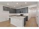 Stylish kitchen with grey cabinets, granite countertops, a spacious island and stainless steel appliances at 404 Duskywing Dr, Goose Creek, SC 29445
