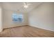 Bright bedroom featuring wood-look flooring, neutral walls, ceiling fan, and a window with neighborhood views at 412 Hainesworth Dr, Charleston, SC 29414