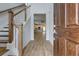 Inviting entryway with hardwood floors, wooden stairs, and a view into the open-concept kitchen at 418 Grove End Rd, Moncks Corner, SC 29461