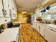 Bright kitchen featuring wooden floors, white appliances, cabinetry, and a breakfast nook at 422 Academy Rd, Walterboro, SC 29488