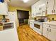A kitchen view featuring a stainless steel washer/dryer, white appliances and cabinetry at 422 Academy Rd, Walterboro, SC 29488