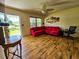 Bright living room features wood-look floors, a ceiling fan, and an eye-catching red sectional at 422 Academy Rd, Walterboro, SC 29488