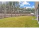 Expansive backyard featuring a lush lawn, privacy fence, mature trees, and a view of the home's exterior at 4316 Cotton Flat Rd, Summerville, SC 29485