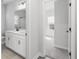 Bathroom with double sinks, white cabinetry, and views of the bedroom at 4316 Cotton Flat Rd, Summerville, SC 29485