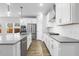 Bright, modern kitchen featuring stainless steel appliances, white cabinetry, and a large island with a sink at 4316 Cotton Flat Rd, Summerville, SC 29485