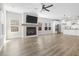 Spacious open-concept living room featuring wood floors, a fireplace, ceiling fan, and access to the kitchen at 4316 Cotton Flat Rd, Summerville, SC 29485