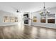 Open-concept living room featuring wood floors, a fireplace, a ceiling fan, and abundant natural light at 4316 Cotton Flat Rd, Summerville, SC 29485