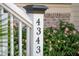 Close-up of an address number on a white post in front of a charming house at 4343 Ten Shillings Way, Ravenel, SC 29470