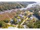 Aerial view of homes nestled amongst lush greenery, showcasing their proximity to the river and marshlands at 4343 Ten Shillings Way, Ravenel, SC 29470
