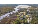 Aerial view of waterfront homes with marsh and river access, surrounded by picturesque trees and landscaping at 4343 Ten Shillings Way, Ravenel, SC 29470