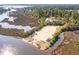 A picturesque aerial view showcasing the sandy boat launch area and the surrounding natural beauty of the waterfront community at 4343 Ten Shillings Way, Ravenel, SC 29470