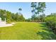 Expansive, lush green backyard with manicured lawn and tall trees, perfect for outdoor activities at 4343 Ten Shillings Way, Ravenel, SC 29470