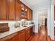 Charming bar area with custom cabinets, wine cooler, granite countertop and hardwood floors at 4343 Ten Shillings Way, Ravenel, SC 29470