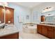 Elegant bathroom featuring a soaking tub, double vanity with granite countertop, and shuttered window at 4343 Ten Shillings Way, Ravenel, SC 29470