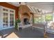 Inviting covered porch features a brick fireplace, comfortable seating, and serene outdoor ambiance at 4343 Ten Shillings Way, Ravenel, SC 29470