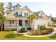 Charming two-story home features a quaint porch, manicured lawn, and elegant landscaping at 4343 Ten Shillings Way, Ravenel, SC 29470