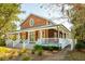 Charming home with a full wrap-around porch, complimented by rocking chairs and lush landscaping at 4343 Ten Shillings Way, Ravenel, SC 29470