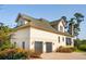 View of rear of house highlighting a two car garage and green shingled roof at 4343 Ten Shillings Way, Ravenel, SC 29470