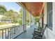 Inviting front porch with rocking chairs, wooden ceiling, and a peaceful neighborhood view at 4343 Ten Shillings Way, Ravenel, SC 29470