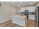 Kitchen with stainless steel appliances, white cabinetry, blue backsplash and a quartz island at 447 Duskywing Dr, Goose Creek, SC 29445