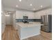 Bright kitchen featuring white cabinets, stainless steel appliances, blue backsplash and island at 447 Duskywing Dr, Goose Creek, SC 29445