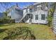 Inviting backyard featuring lush green grass, surrounding trees, and exterior stairs leading to the upper level of the home at 45 Bogard St, Charleston, SC 29403