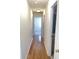 Hallway with hardwood flooring and white walls leads to a carpeted room with natural light at 5208 Fernland Way, North Charleston, SC 29420