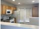 Well-lit kitchen featuring natural wood cabinets, modern appliances, and access to the backyard at 5208 Fernland Way, North Charleston, SC 29420