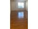 Well-lit living room with hardwood floors and a bright window, creating a warm and welcoming atmosphere at 5208 Fernland Way, North Charleston, SC 29420