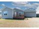 A lovely home with a cozy wooden deck in the backyard, surrounded by green grass and trees at 7919 New Ryder Rd, North Charleston, SC 29406
