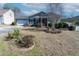 A beautiful single-Gathering home featuring a well-manicured front yard, lush landscaping, and a two-car garage at 7919 New Ryder Rd, North Charleston, SC 29406
