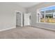 Bright bedroom featuring neutral walls, carpet floors, a window, and a view of the home's backyard at 810 Gentle Breeze Dr, Summerville, SC 29486