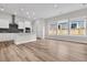 Spacious living area with wood-look floors, white kitchen, and natural light at 810 Gentle Breeze Dr, Summerville, SC 29486